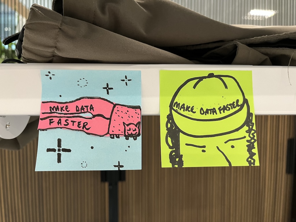 Drawings by Paul Downey. One shows Nyan Cat flying ahead next to the phrase ‘Make Data Faster’. The other shows a lad wearing a cap with ‘Make Data Faster’ on it.